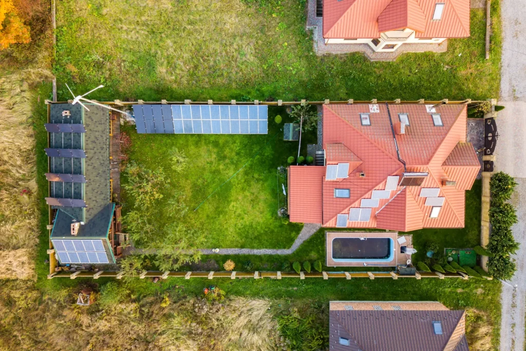 Vogelperspektive auf ein Einfamilienhaus mit Garten mit Solarpanels auf Dach und Garten